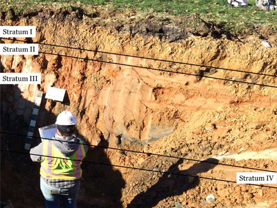 Worker in front of layers of dirt